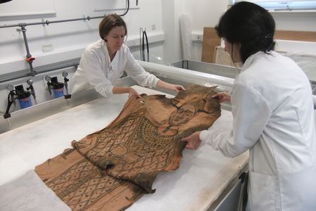 Conservators carefully unfold the shroud, which had been stored in a brown paper parcel for some 80 years. 