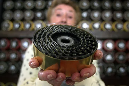 A former bombe operator shows the back of a drum from the decryption machine at Bletchley Park.