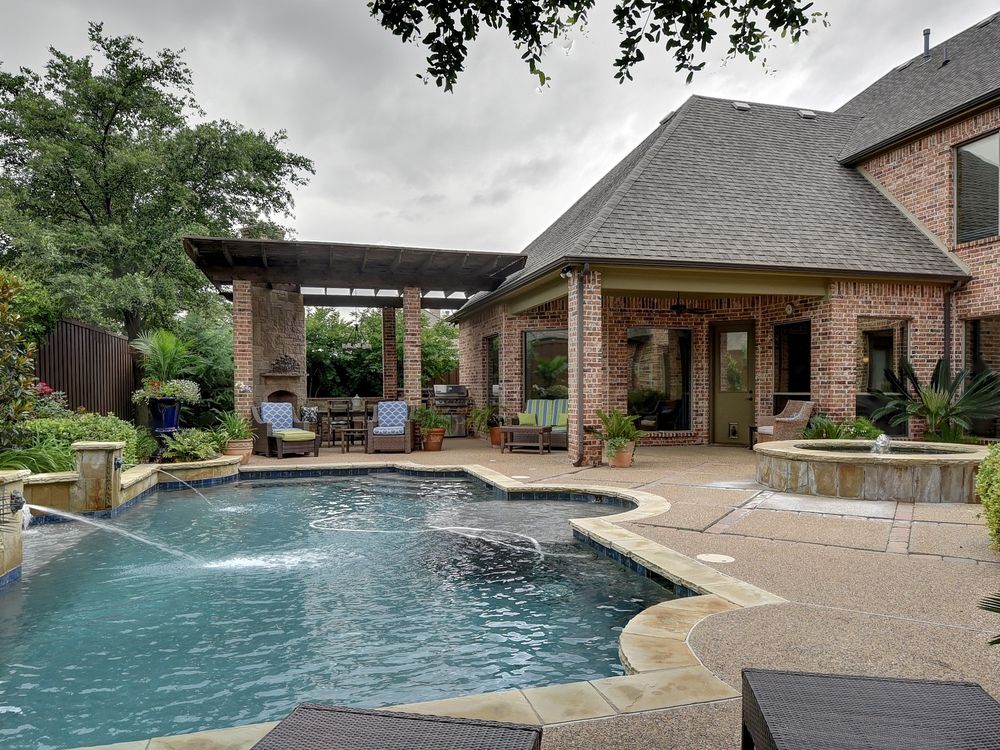 Swimming pool in backyard of brick house