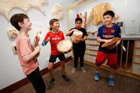 Playing with Native American instruments, fifth-graders from New York City Public School 276 play with percussion instruments made of pelts and other fibers.  