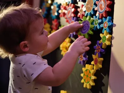 Young child experiences hands-on play experience with objects