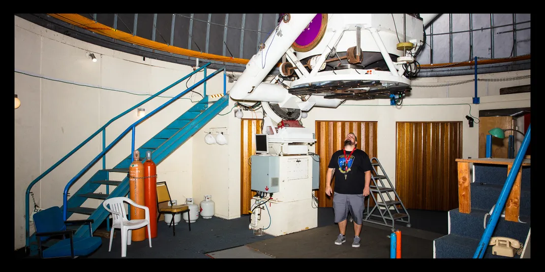 Rankin stands beneath telescope equipment in the observatory