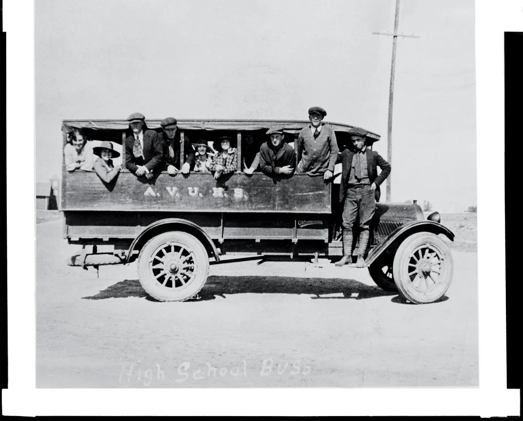 1909 black and white photo of children on a school bus