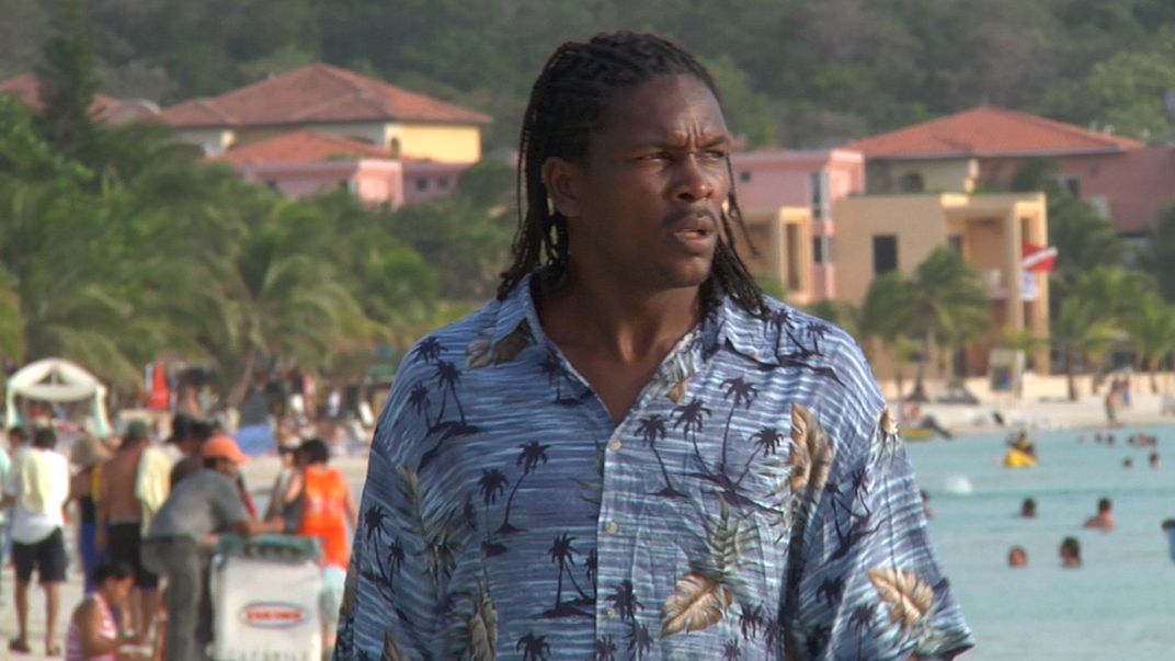 A person walking on a busy beach.