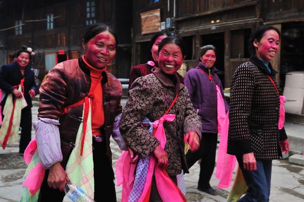 Miao people of China returning from a wedding banquet.  Their bright painted faces symbols fertility and happiness. thumbnail