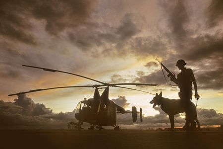 Combat photographers shot everything from napalm drops to this deceptively bucolic 1966 image of an airman and his sentry dog guarding an HH-43 at Pleiku.