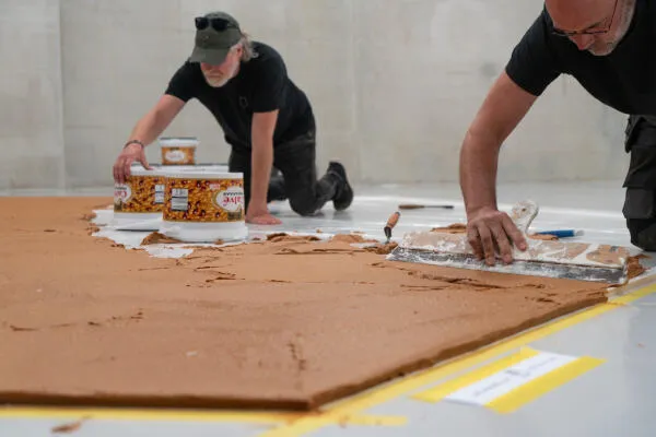 Museum workers spread peanut butter across a platform