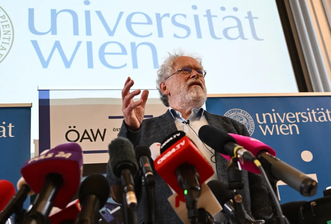 Anton Zeilinger speaks in front of microphones at a press conference.