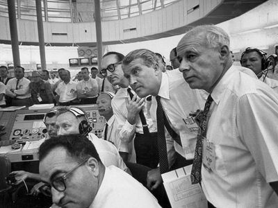 Wernher von Braun (center, standing), George Mueller (to his right) and other members of the NASA team watch an Apollo test flight in 1964.