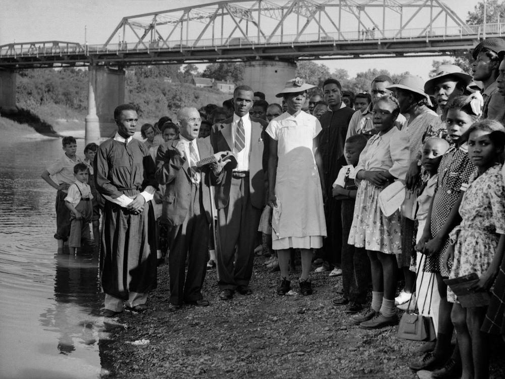 A preacher with a baptismal group on the bank of the Tombigbee River, circa 1930s