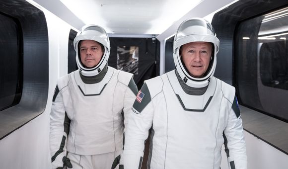 Astronauts Bob Behnken and Doug Hurley walk through Crew Access Arm in SpaceX spacesuits during a dress rehearsal for the first crewed SpaceX launch.