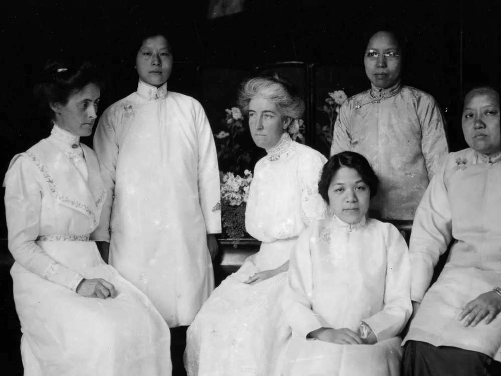 Tien Fuh Wu (standing in the back, on the left) and Donaldina Cameron (seated, center) with a group of women who may have been Mission Home staffers. _ Courtesy of Louis B. Stellman, California State Library..png