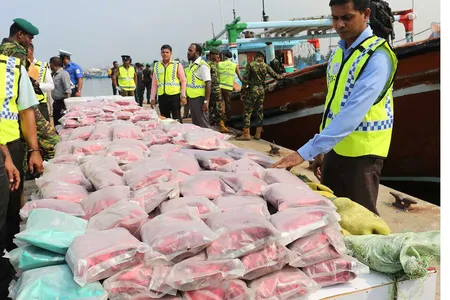 Sri Lankan police stand next to over $33 million worth of heroin and crystal methamphetamine seized from two foreign trawlers.