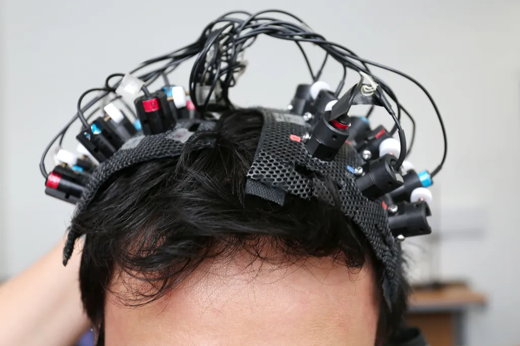 A man's head with many wires and electrodes attached to his scalp