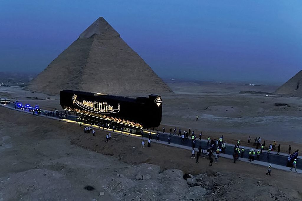 View of boat being moved past Pyramids of Giza