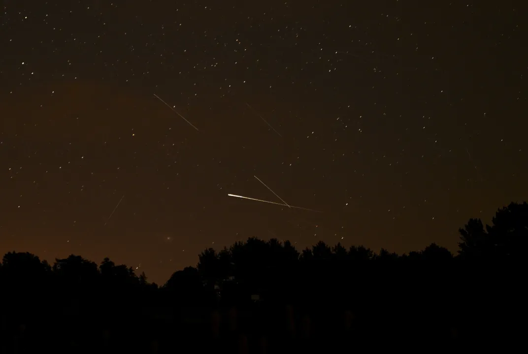 a dim night sky with a few streaks of light