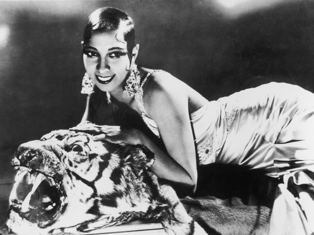 Josephine Baker lying on a tiger rug in a silk evening gown in 1925