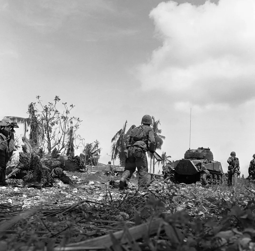 Marines move forward behind a tank during the Battle of Guam in July 1944.