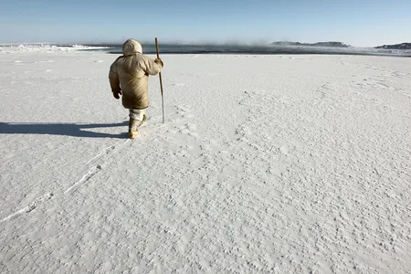 Hunters, trappers and other land users in the North are using Siku, a mobile app named after the Inuktitut word for &ldquo;sea ice,&rdquo; to share environmental information, including ice conditions. Here, an Inuit hunter prepares to test the safety of sea ice near Sanikiluaq, Nunavut, with a harpoon.