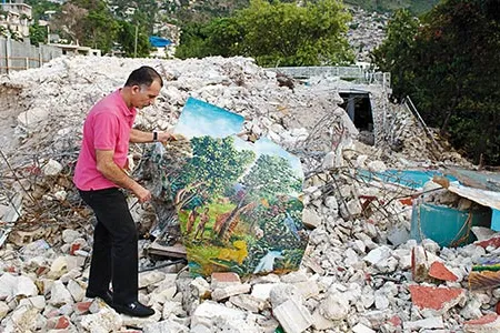 "We had 12,000 to 15,000 paintings here," says Georges Nader Jr., with a Paul Tanis work at the remains of his family's house and museum near Port-au-Prince.