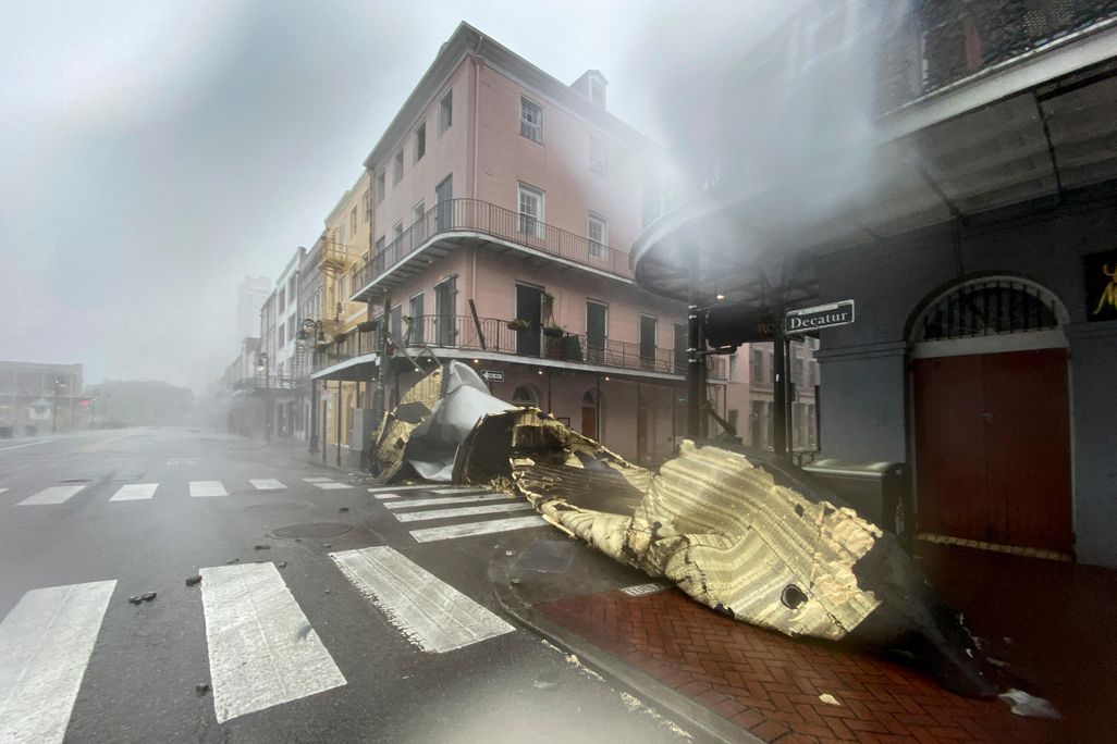 A view partially obscured by rain of a historic building at an intersection, with a part of a roof or building obstructing the entire road