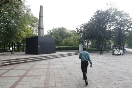 A man walks past the covered Confederate monument in Linn Park on August 18, 2017.
