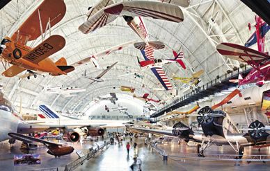 Art Scholl's Chipmunk (center, with the red and white stripes and the leading edges of the wings painted blue) hangs in the Boeing Aviation Hangar at the National Air and Space Museum's Steven F.Udvar-Hazy Center.