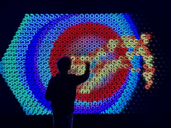 A boy plays with a colorful exhibit at the Exploratorium. thumbnail