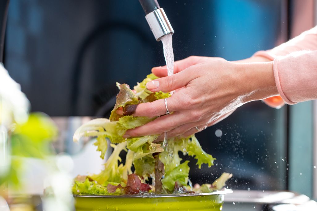 person washing lettuce
