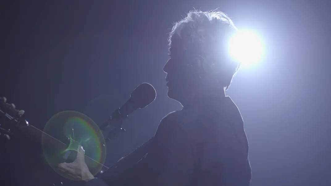 Joan Baez playing a tambourine