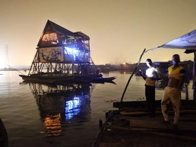 Residents of Makoko look on its floating school at night in December. Today, the school is nothing more than an empty, broken platform. 