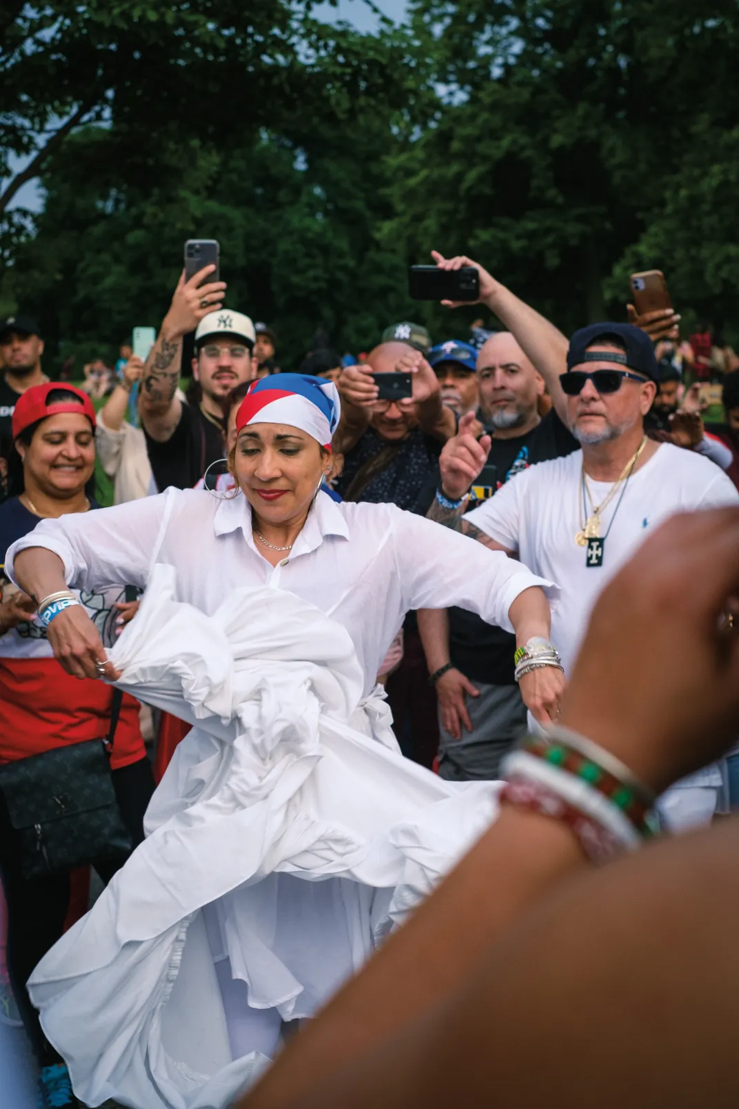 a woman wearing the colors of Puerto Rico dances the bomba to a crowd