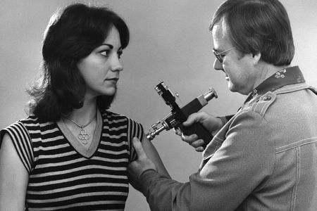 This 1976 photograph shows a woman receiving a vaccination during the nationwide swine flu vaccination campaign. 