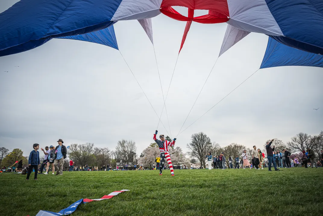 15 - A veteran wearing a stars-and-stripes outfit sets a red, white and blue kite aloft at the annual Blossom Kite Festival on the National Mall.