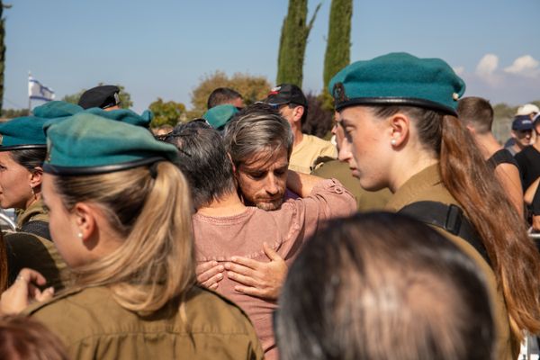 Mourners embrace at the funeral of five wartime family members thumbnail