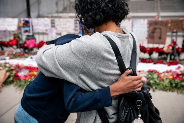 Mother and son hug in front of a BLM monument thumbnail