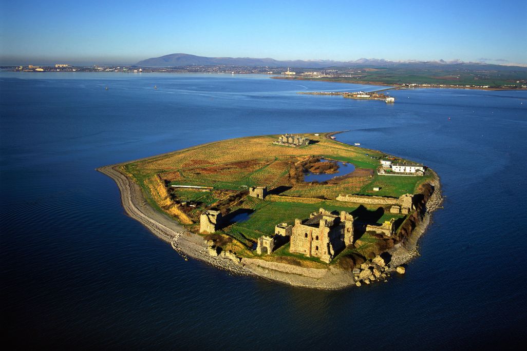 Aerial view of very small green island in ocean