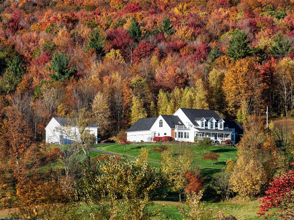 A large estate in a Vermont hillside photographed in fall foliage