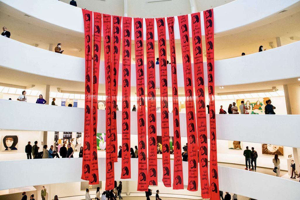 Red banners with Mahsa Amini’s face cover the Guggenheim spiral in anonymous protest action