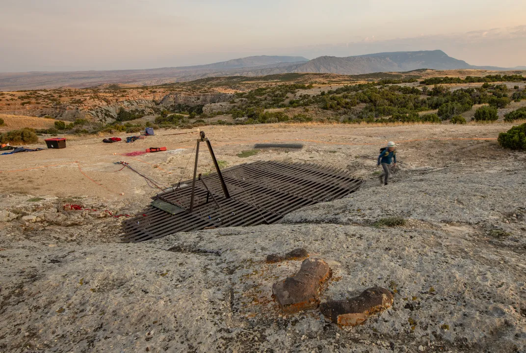 A grate above the cave’s opening helps spare modern animals the fate of their Pleistocene forebears. Researchers enter through a latched door.