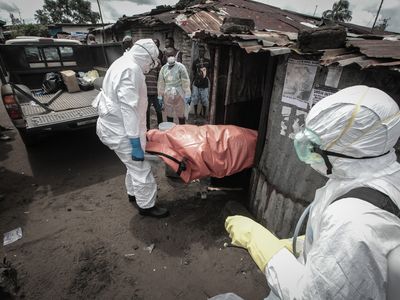 Garmai Sumo with the Liberian red cross supervises a burial team as they pull out the body of 40-year-old Mary Nyanforh, in Monrovia, Liberia, on October 14, 2014.