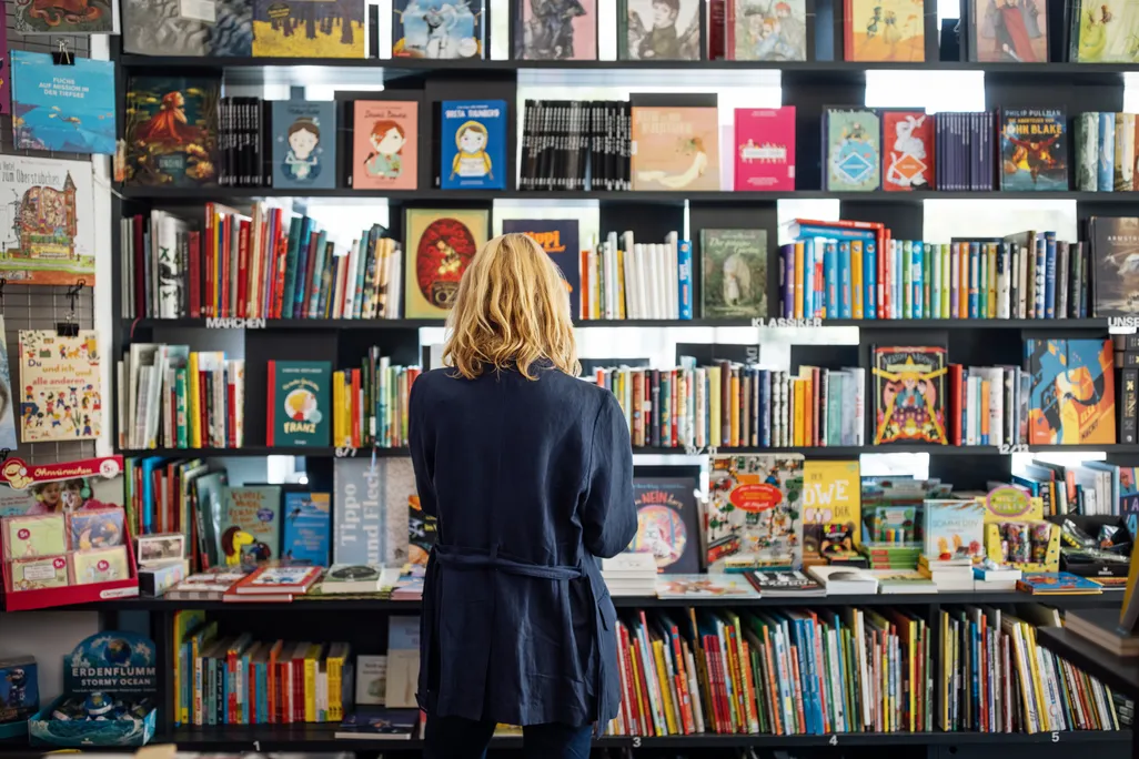 Rear view of a woman looking at books at a bookshop.