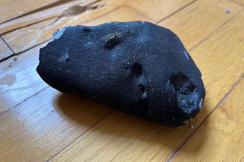 close-up of a black rock on a hardwood floor