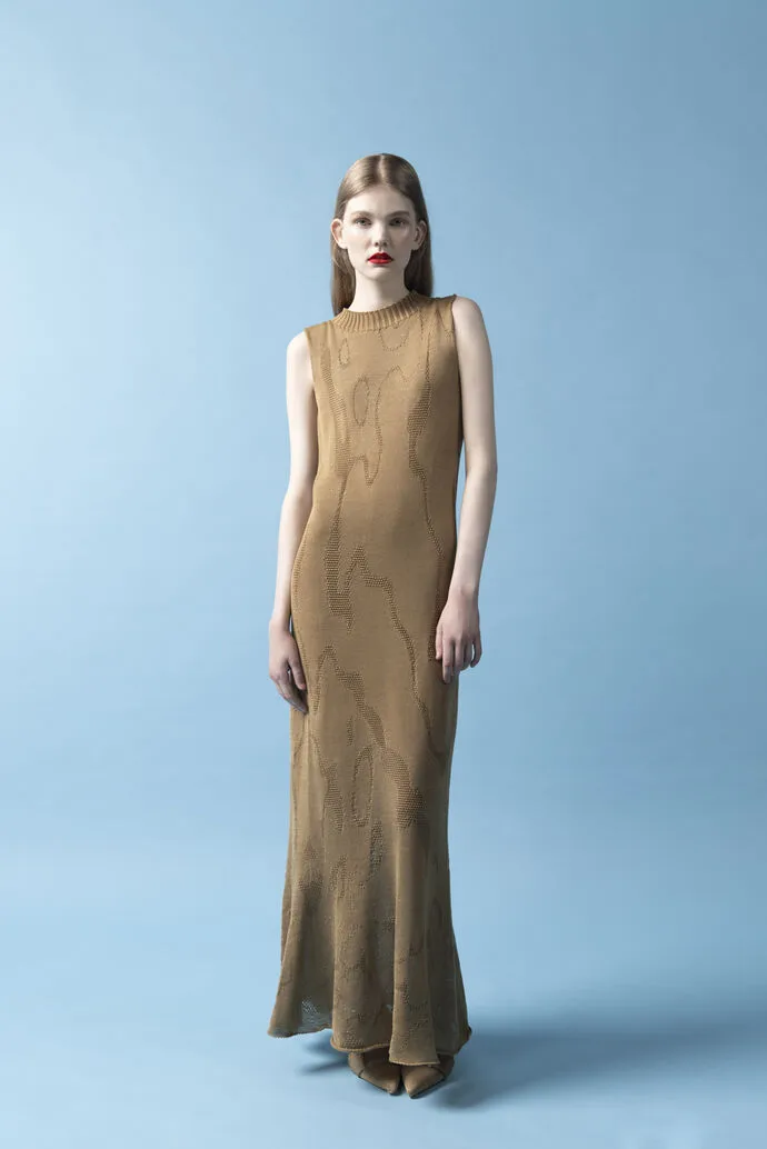 A woman wearing a tannish-brown, long, knit maxi dress
