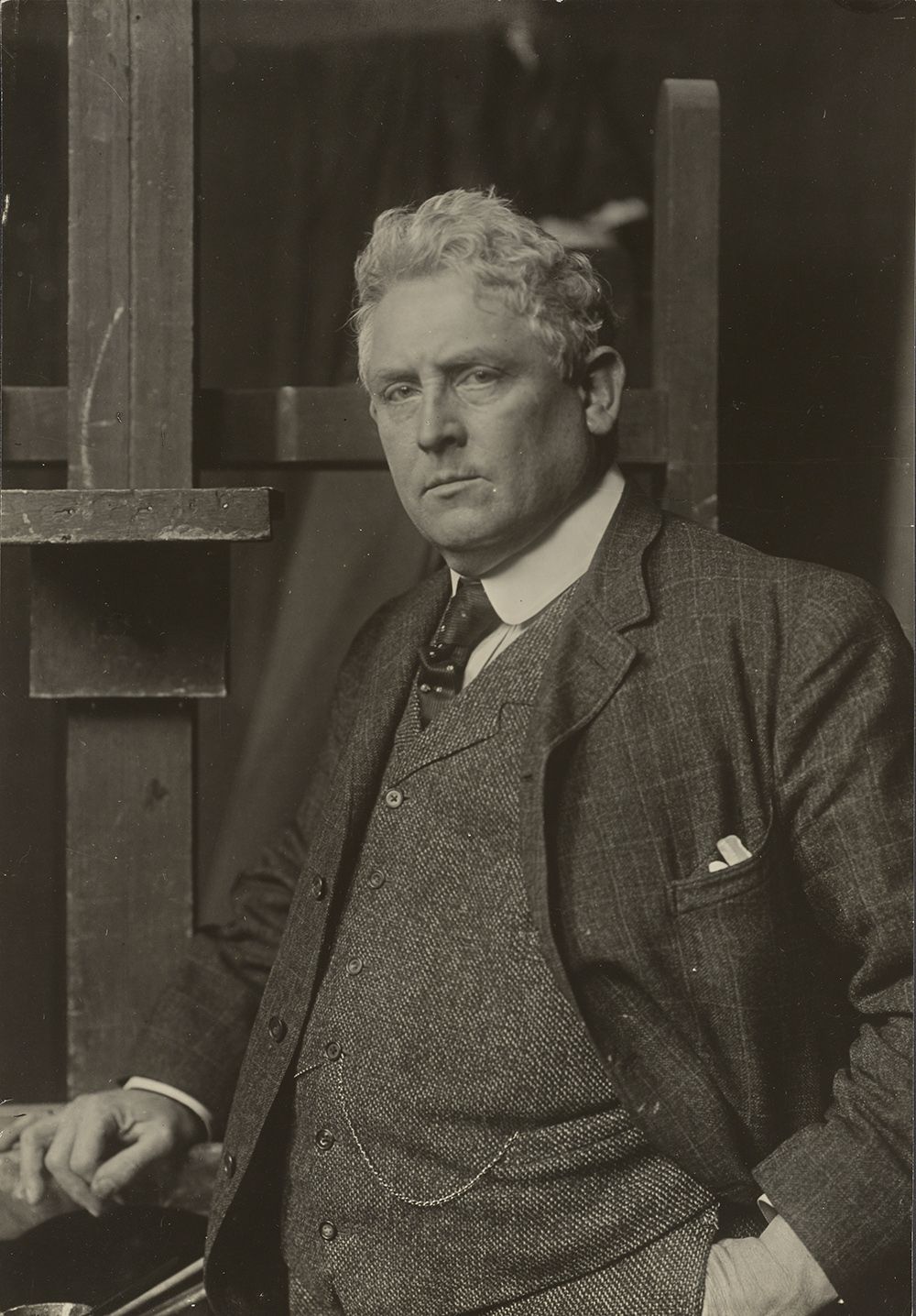 Julian Alden Weir in his studio wearing a suit and tie in a formal portrait.