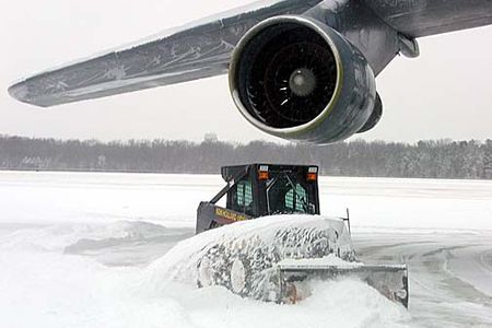 A member of the 436th Aircraft Maintenance Squadron clears the snow around a C-5 Galaxy at Dover Air Force Base this morning.  Five inches of snow fell overnight, and freezing rain followed by more snow is expected over the next 24 hours. (Photo by Lt. Col. Jon Anderson)