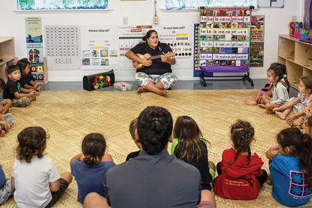 Nāoli Weller, a nursery school teacher at Nāwahī, leads her class in traditional songs. In the room hang signs that help pupils master the Hawaiian language.