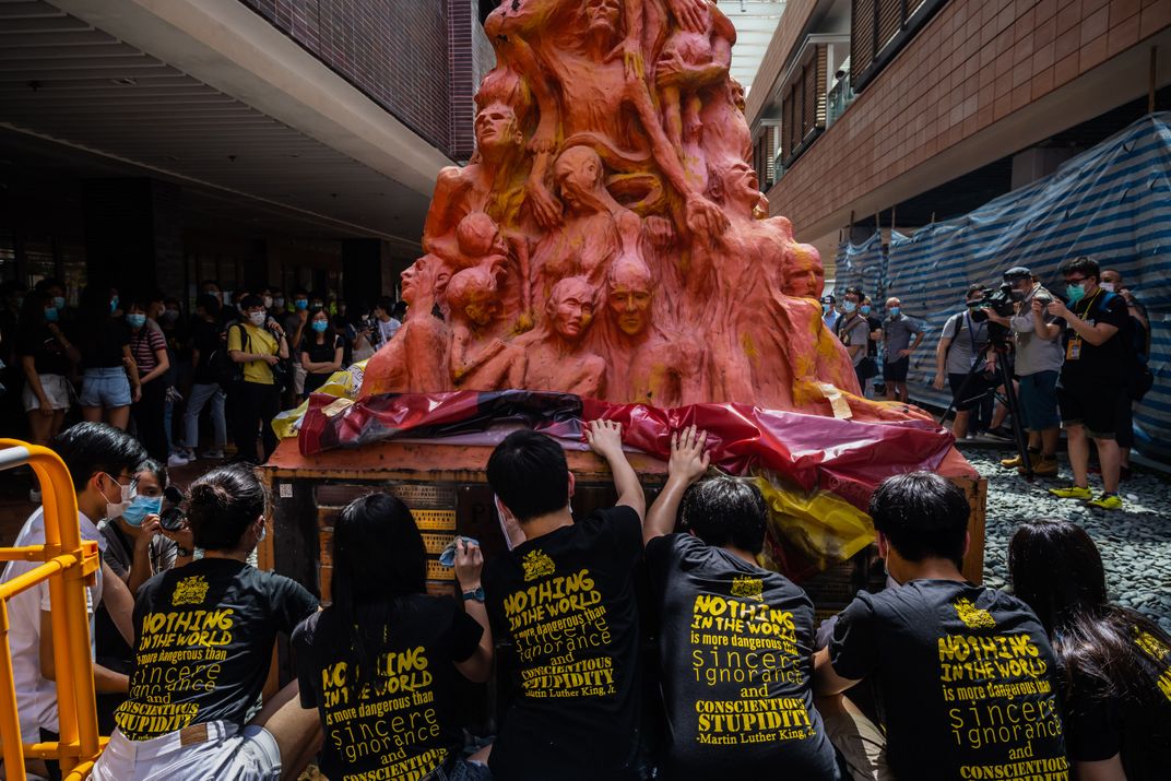 University students clean the "Pillar of Shame" statue on June 4, 2020