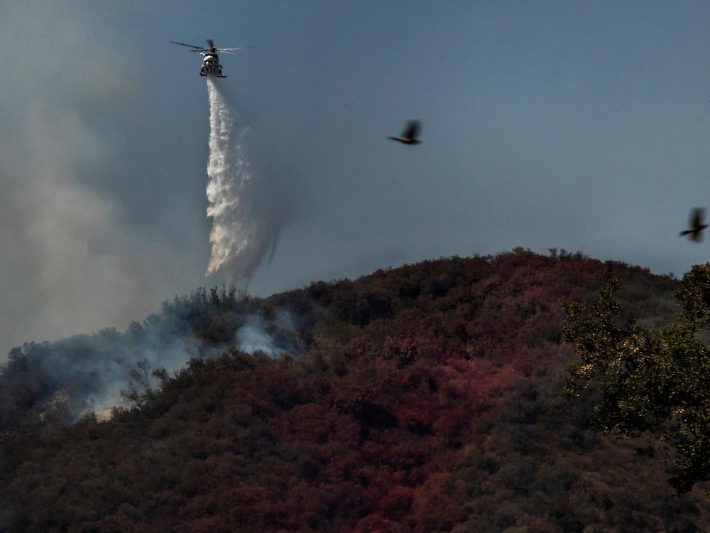 Firefighters in helicopters battle a 1,300 acre brush fire in Pacific Palisades on May 17.