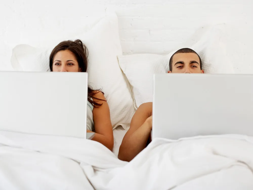 Couple on Laptops in bed